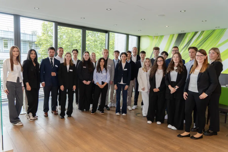 Gruppe junger Erwachsener in Businesskleidung steht in einer Kantine
