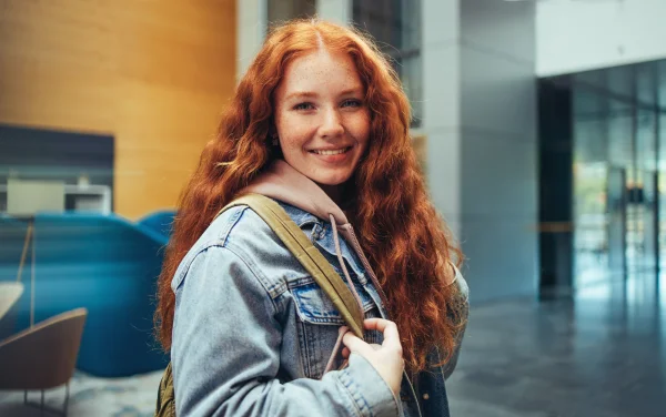 A young girl with a backpack in a hallway