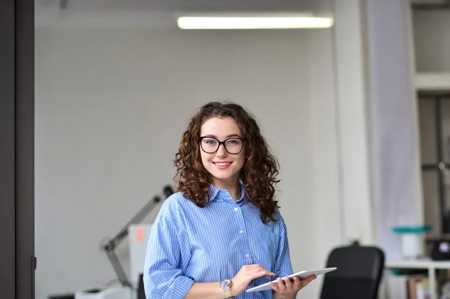 Junge Frau mit blauem Hemd und Tablet in der Hand