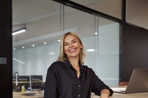 Blonde Frau mit schwarzem Hemd in einem Büro